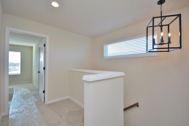 hallway with a healthy amount of sunlight and light carpet