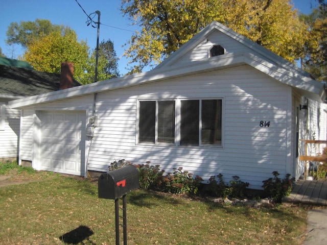 view of side of home featuring a yard and a garage