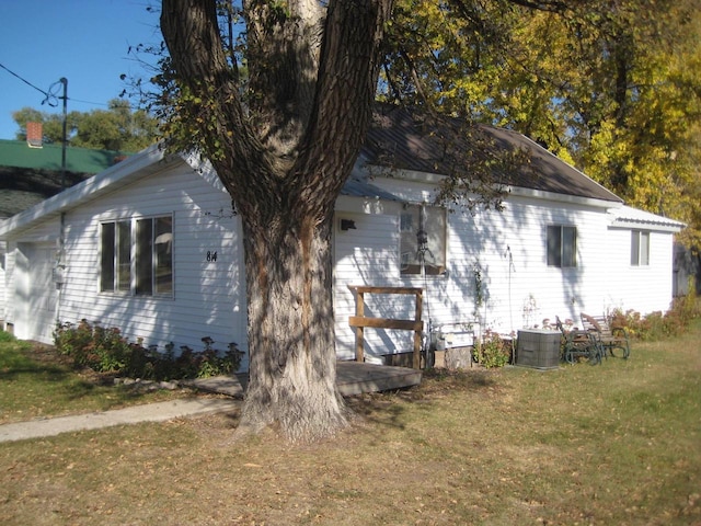 view of property exterior with a deck and a lawn