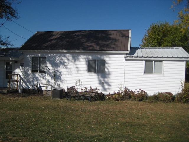 view of side of home featuring a yard and central AC unit