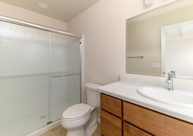 bathroom with vanity, toilet, and a shower with shower door