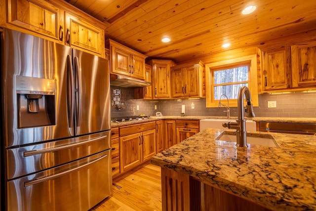 kitchen featuring wood ceiling, sink, light stone countertops, light wood-type flooring, and appliances with stainless steel finishes