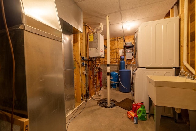 utility room with water heater and stacked washer and clothes dryer