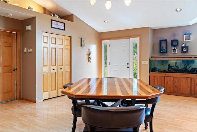 dining room featuring lofted ceiling and light hardwood / wood-style flooring