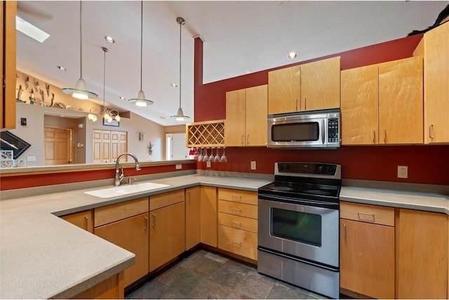 kitchen featuring kitchen peninsula, hanging light fixtures, appliances with stainless steel finishes, vaulted ceiling, and sink