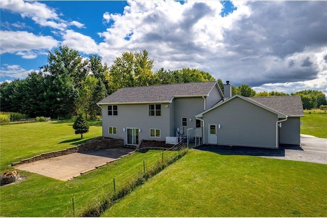 rear view of house with a patio and a yard