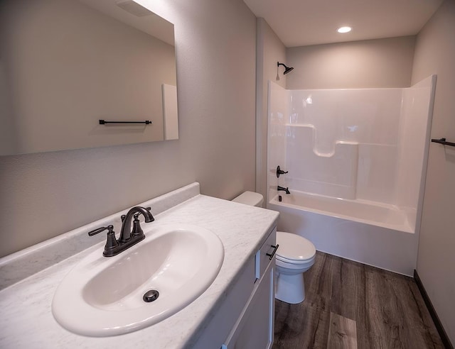 full bathroom featuring vanity, hardwood / wood-style floors, shower / washtub combination, and toilet