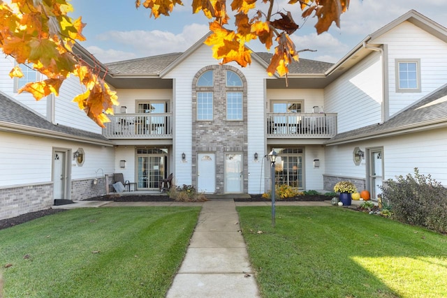 view of front of property with a balcony and a front lawn