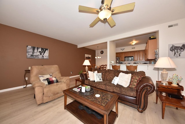 living room with ceiling fan and light wood-type flooring