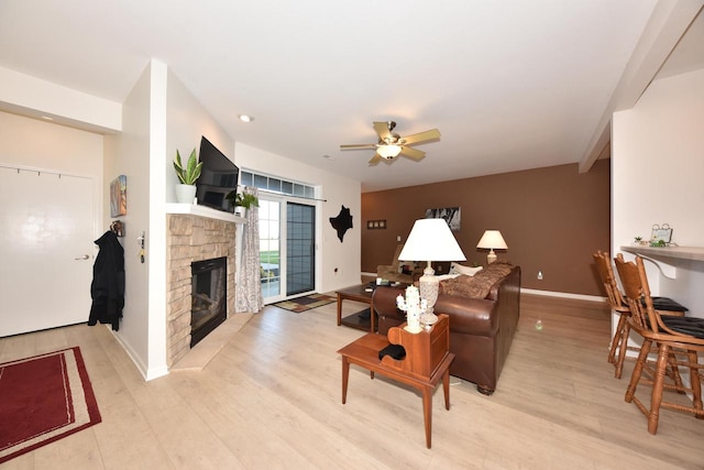 living room with light hardwood / wood-style floors, a fireplace, and ceiling fan