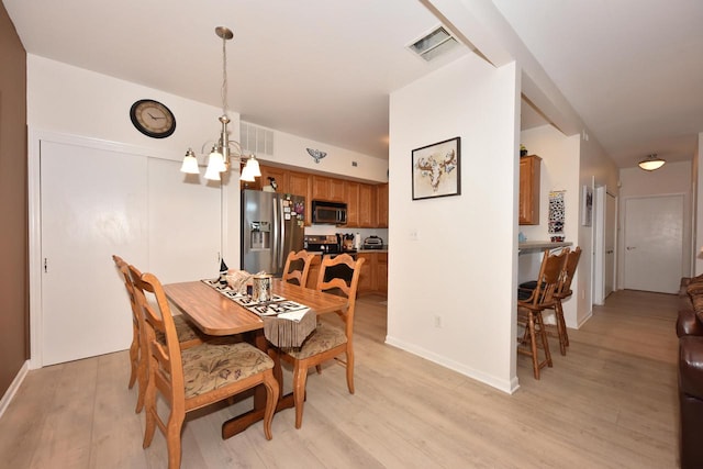 dining room featuring a notable chandelier and light wood-type flooring