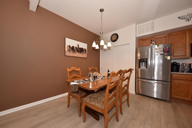 dining area featuring light hardwood / wood-style flooring and a chandelier