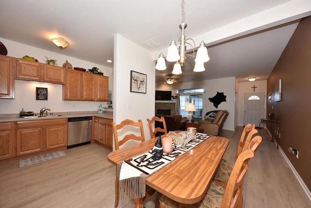 dining room featuring sink, light hardwood / wood-style flooring, and ceiling fan with notable chandelier