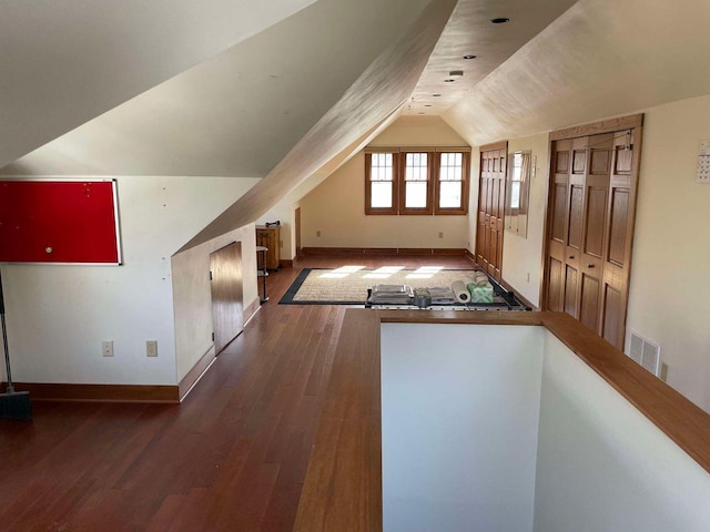 additional living space with lofted ceiling and dark hardwood / wood-style floors