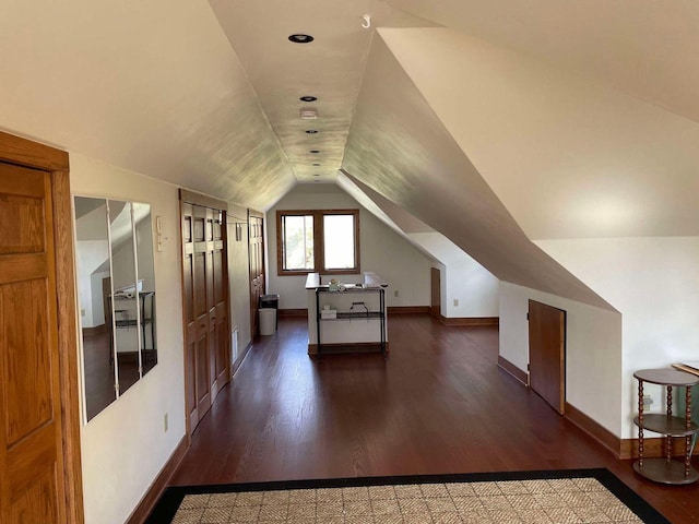 bonus room featuring dark wood-type flooring and vaulted ceiling