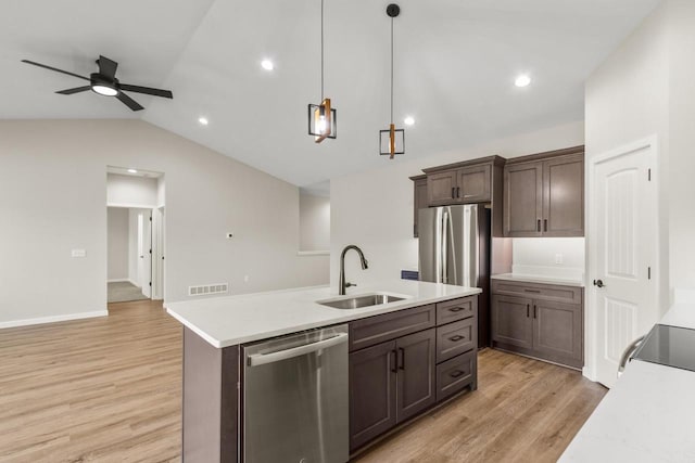 kitchen featuring dishwasher, light hardwood / wood-style flooring, hanging light fixtures, sink, and vaulted ceiling