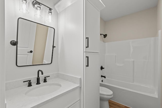 full bathroom with vanity, toilet, hardwood / wood-style flooring, and shower / tub combination