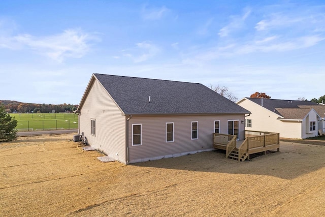 back of property with central AC and a wooden deck