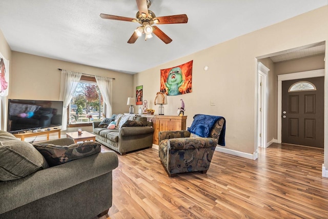 living room with light wood-type flooring and ceiling fan