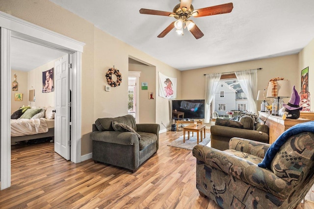 living room with light hardwood / wood-style floors and ceiling fan