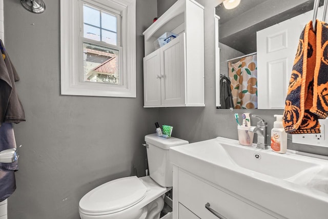 bathroom with toilet, curtained shower, and vanity