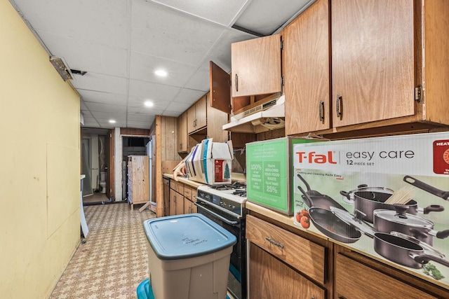 kitchen with white range with gas stovetop, a paneled ceiling, and range hood