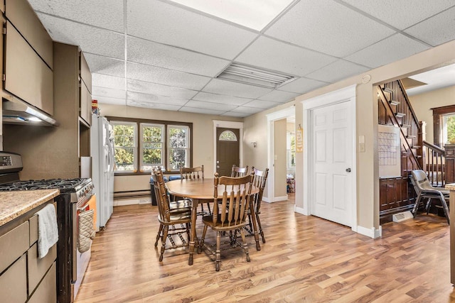 dining area with a paneled ceiling, light hardwood / wood-style flooring, and plenty of natural light