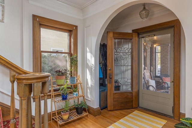 doorway to outside with crown molding and light hardwood / wood-style floors