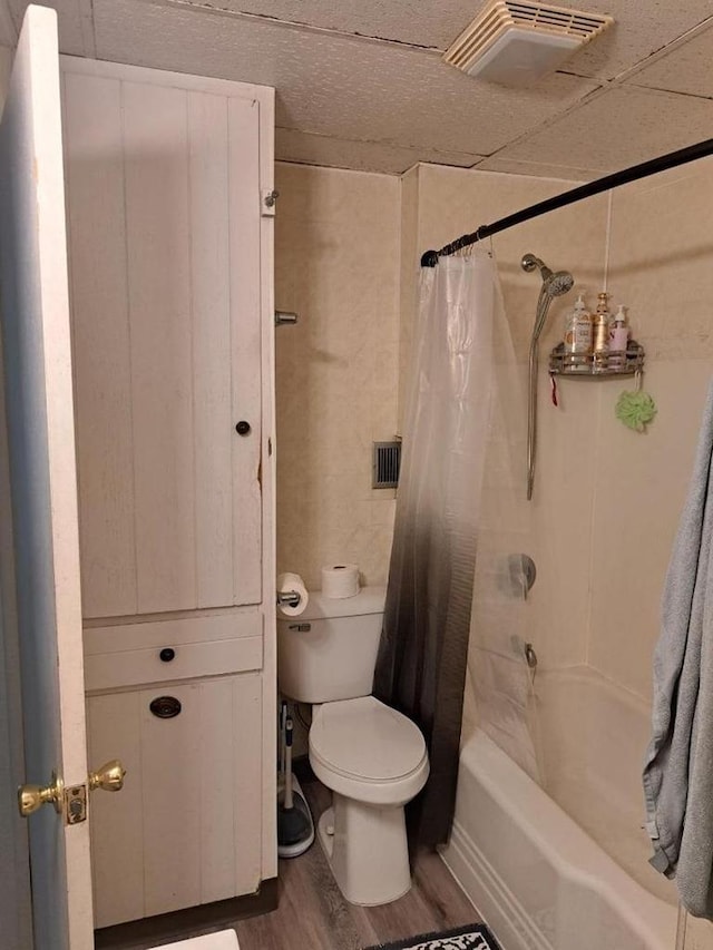 bathroom with toilet, shower / tub combo with curtain, and hardwood / wood-style flooring