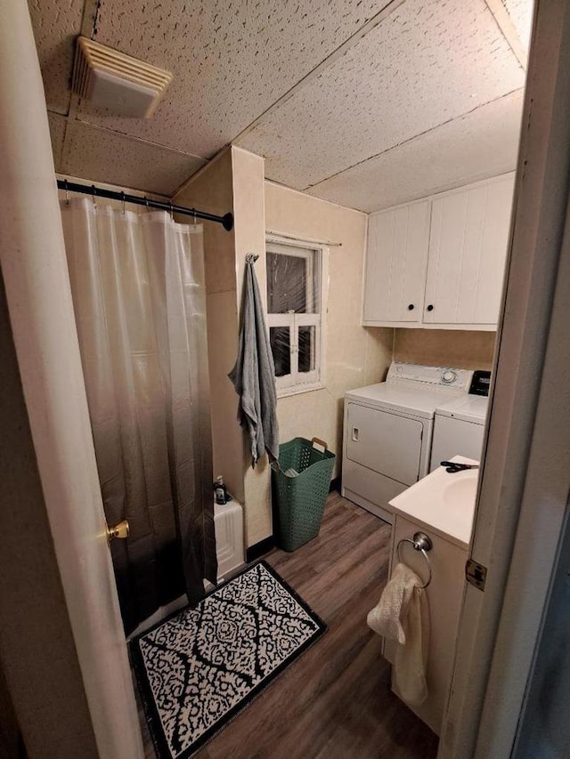 washroom featuring washing machine and dryer and dark wood-type flooring