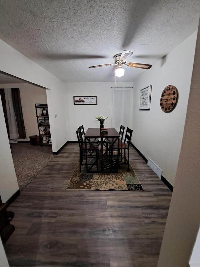 dining area with ceiling fan, dark hardwood / wood-style floors, and a textured ceiling