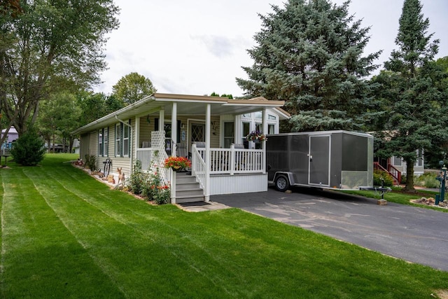 view of front of house featuring covered porch, a front yard, and a carport