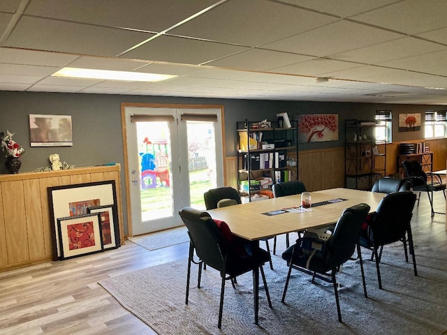 dining space with light wood-type flooring and a drop ceiling