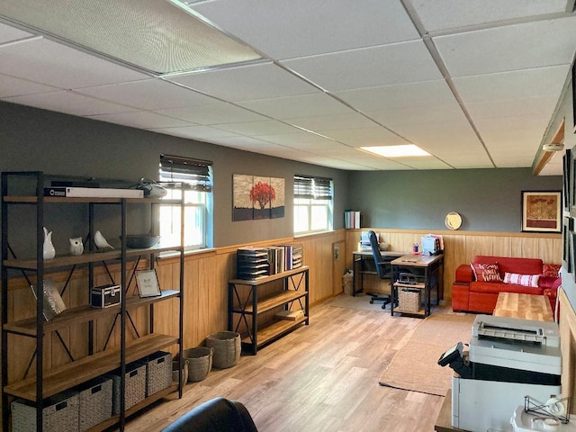 office with a paneled ceiling, wooden walls, and hardwood / wood-style floors