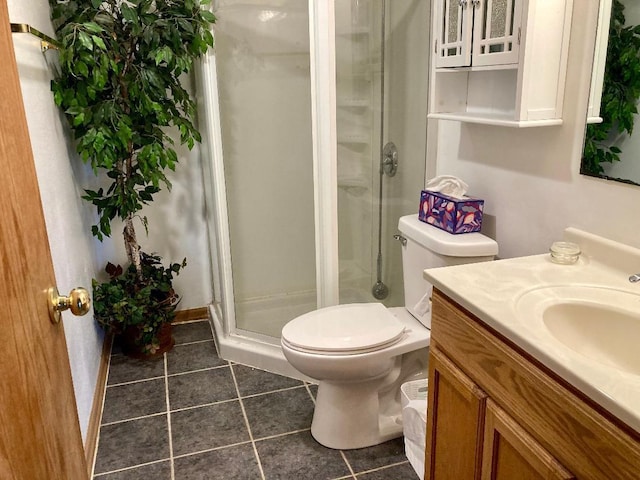 bathroom with tile patterned floors, a shower with door, vanity, and toilet