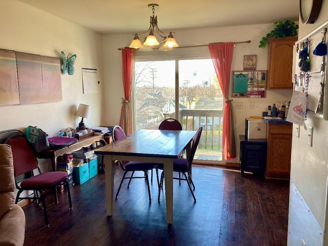 dining room with dark hardwood / wood-style flooring and an inviting chandelier