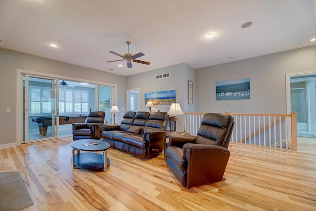 living room featuring light hardwood / wood-style flooring and ceiling fan