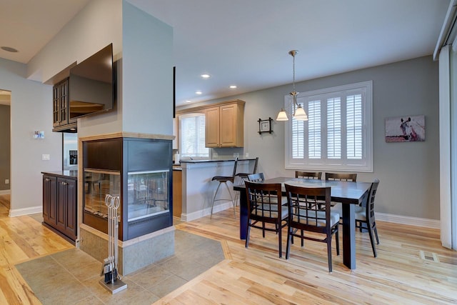 dining area featuring light hardwood / wood-style floors and a chandelier