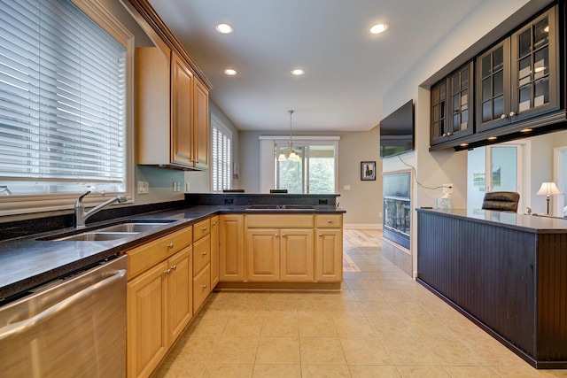 kitchen featuring kitchen peninsula, sink, stainless steel dishwasher, and hanging light fixtures