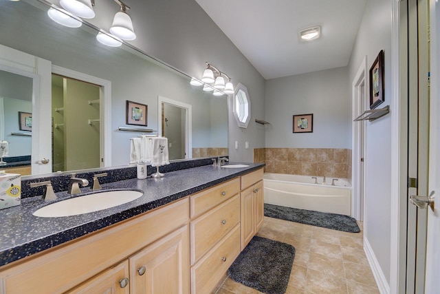 bathroom featuring vanity, tile patterned floors, and a washtub