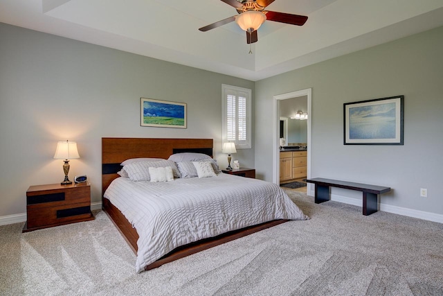 bedroom with connected bathroom, light colored carpet, and ceiling fan