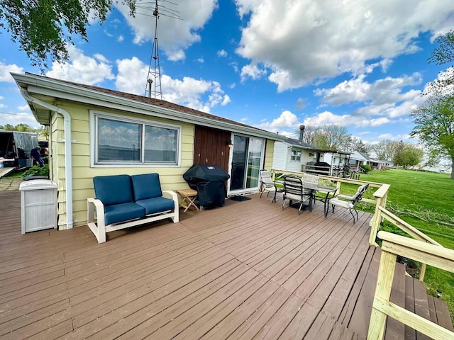 wooden terrace with area for grilling and a yard