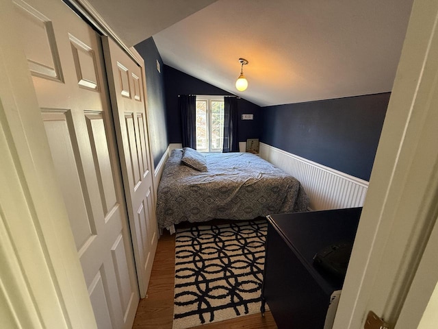 bedroom featuring wood-type flooring and vaulted ceiling