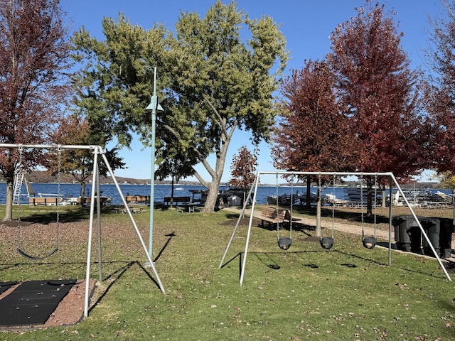 view of play area featuring a lawn and a water view