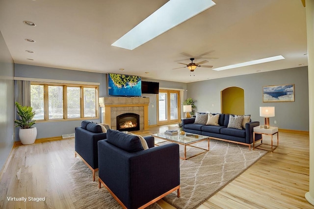 living room with ceiling fan, a healthy amount of sunlight, a fireplace, and hardwood / wood-style floors