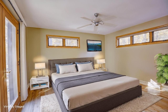 bedroom with multiple windows, light hardwood / wood-style floors, and ceiling fan