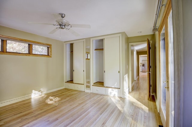 unfurnished bedroom with ceiling fan, multiple closets, and light hardwood / wood-style floors