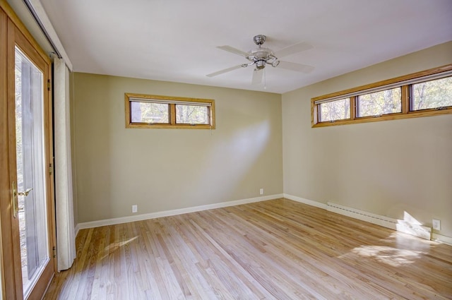 spare room with light hardwood / wood-style flooring, a baseboard heating unit, a healthy amount of sunlight, and ceiling fan