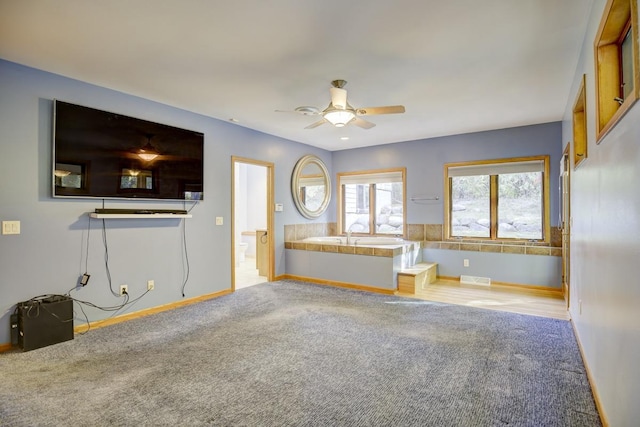 unfurnished living room featuring light carpet and ceiling fan