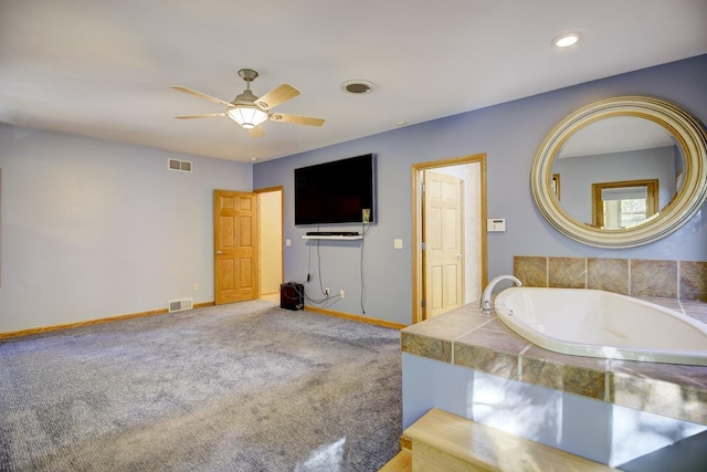 bathroom featuring tiled bath and ceiling fan